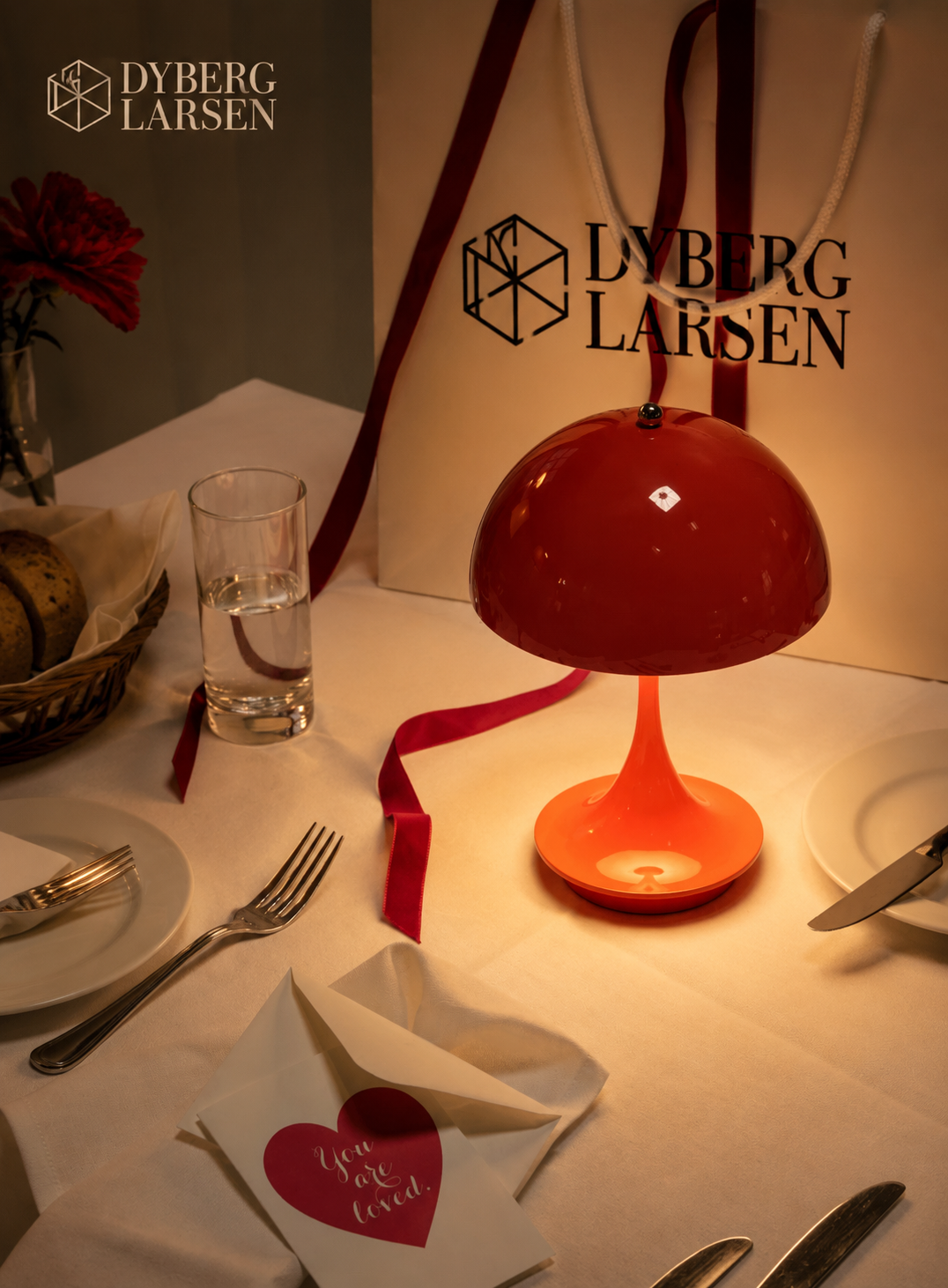 Dyberg Larsen Tischleuchte und Geschenktüte auf einem festlich gedeckten Tisch
